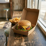 Cheeseburger and fries from Zeropac box displayed at cafe near window