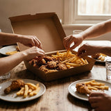 Multiple people sharing fried chicken and fries from Zeropac family box