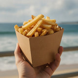 Person holding Zeropac chip box with fries at the beach