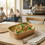 Person enjoying noodle meal in Zeropac Kraft Container at cafe table