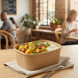 Person enjoying curry meal in Zeropac Kraft Container at cafe setting