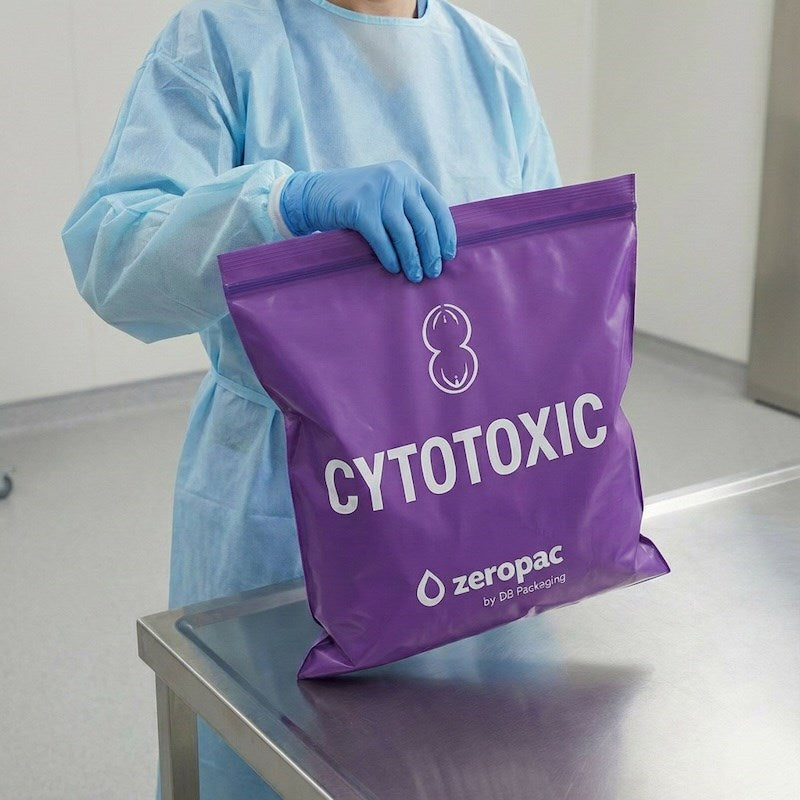 Healthcare worker in protective gown using a purple Zeropac Cytotoxic Ziplock Bag