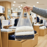Shopper holding Zeropac Dissolvable Singlet Bag with clothes in store