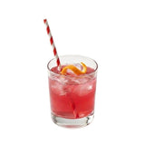Red striped paper straw in fruity cocktail with orange slice