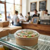 Salad in Zeropac lidded container at cafe on newspaper