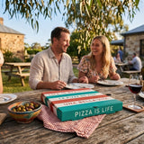 Couple dining outdoors at vineyard with pizza boxes and wine glasses